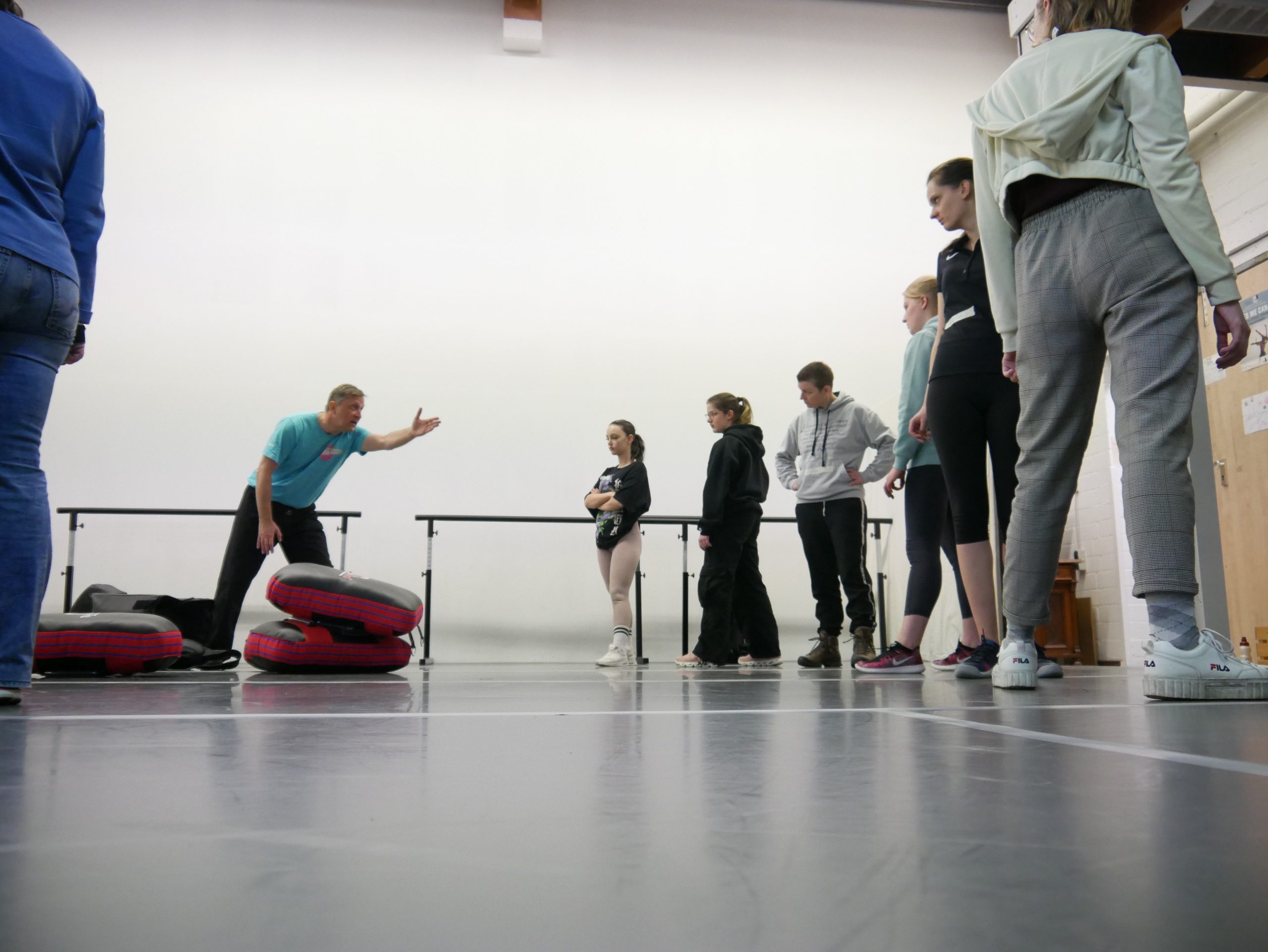 Auf dem Bild sind Frauen und ein Trainer in einem Selbstverteidigungskurs zu sehen