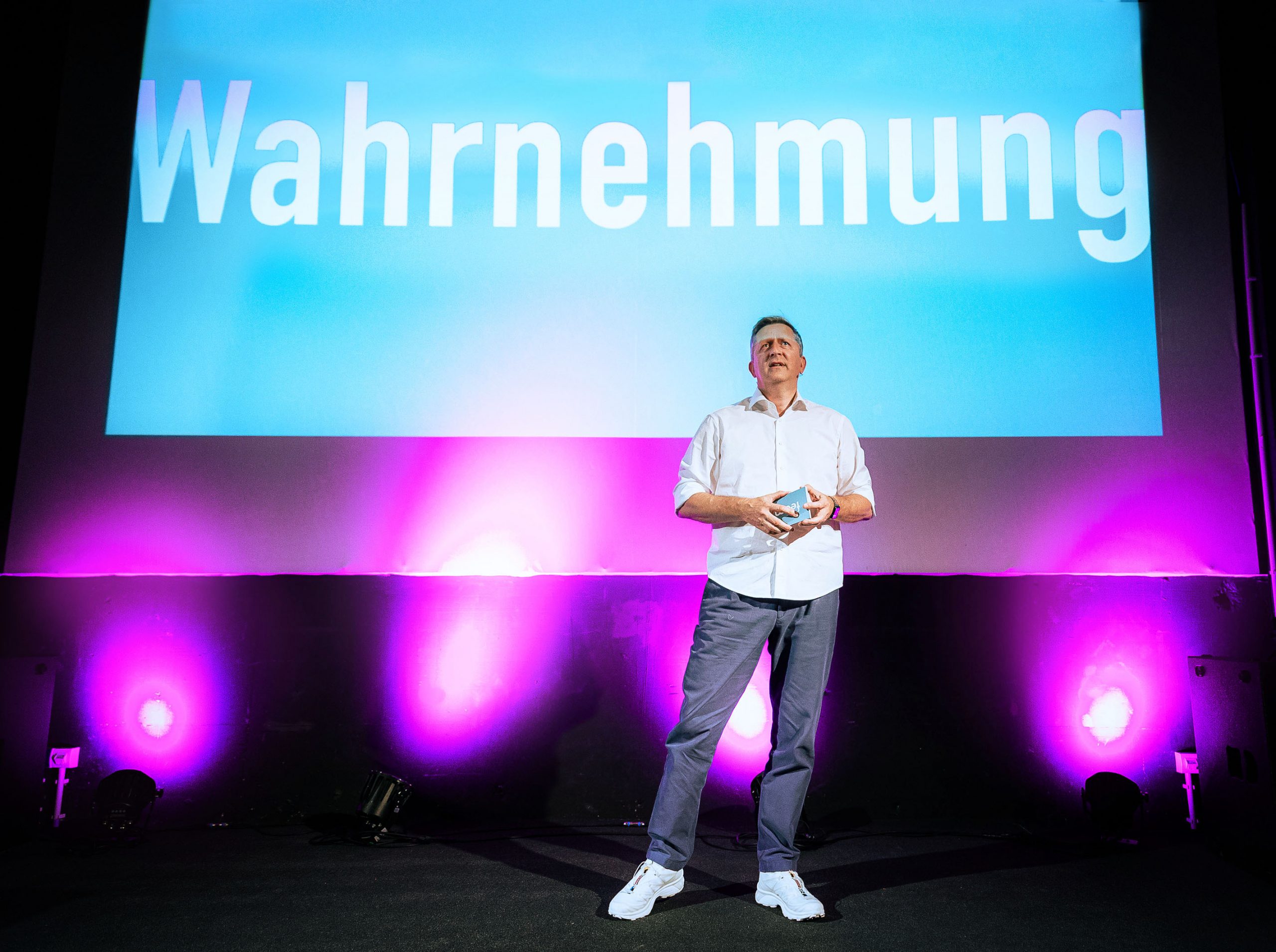 feem-Gründer Till Völzke steht auf einer Bühne.